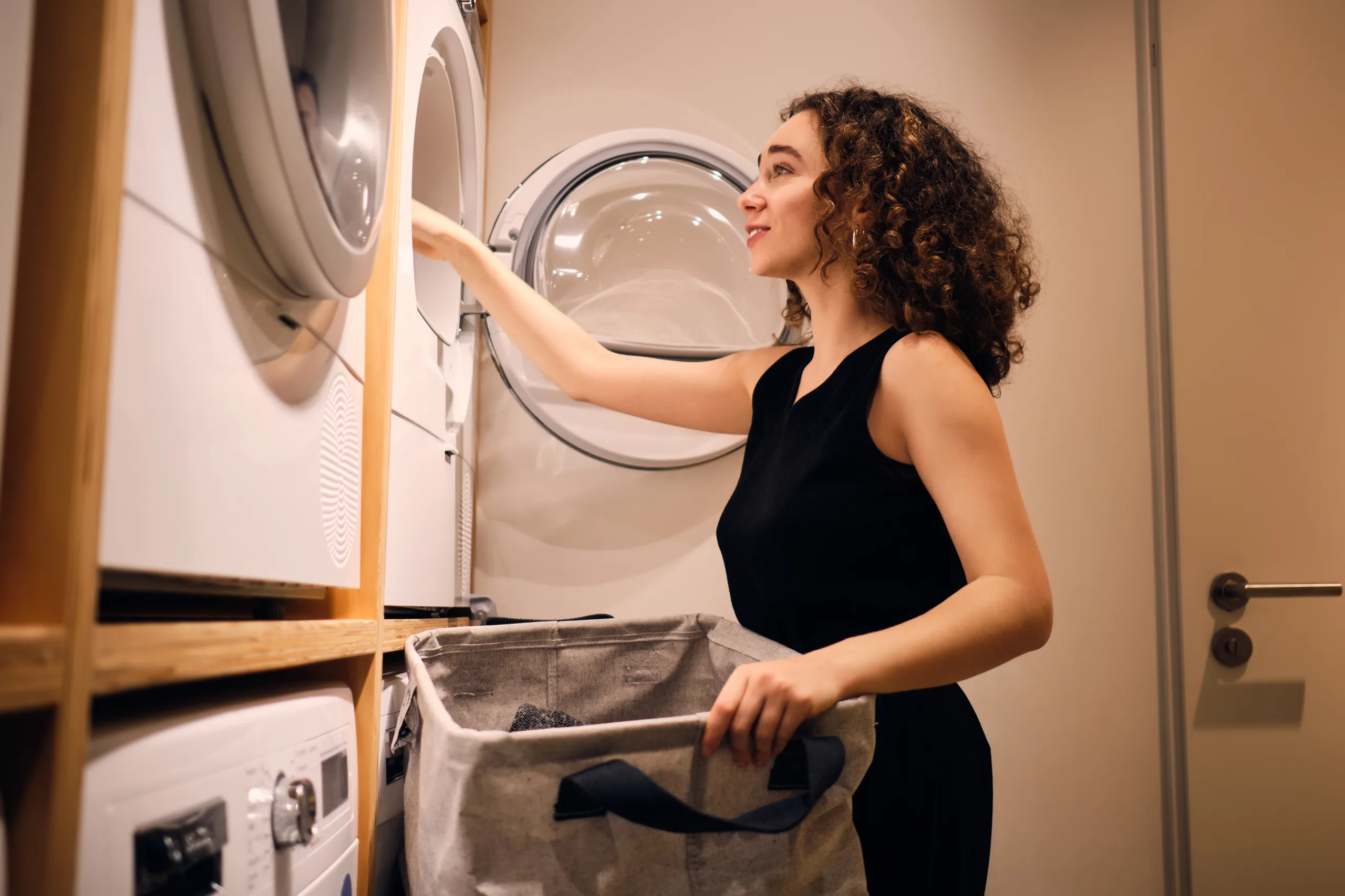 Woman loading clothes in tumble dryer